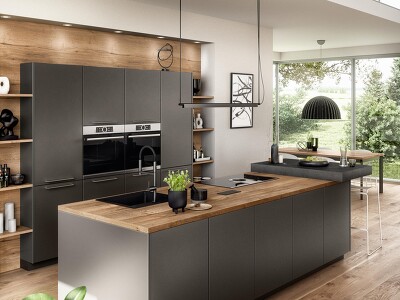 Diese Küche im Dekor ARTIS 937 verbindet elegant die außergewöhnliche Glasoptik in Titanio mit einer Nischenverkleidung in Holzoptik und schafft so Gemütlichkeit.
