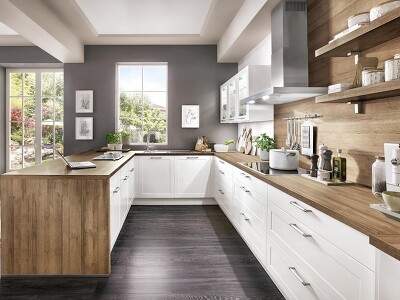 Die Kombination aus alpinweißer CREDO 764-Küche und Arbeitsplatte und Nischenrückwand in Holzoptik wirkt harmonisch. Das offene Wandbord ist puristisch und rustikal zugleich - ideal um die Schmuckstücke der Küche zu präsentieren.