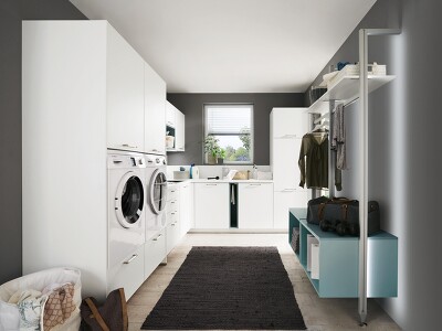Zeitlos schöner Hauswirtschaftraum in LASER 427 Alpinweiß mit Farbakzenten in AQUA 254. Durch den erhöhten Einbau von Waschmaschine und Trockner ist das Be-und Entladen viel komfortabler.
