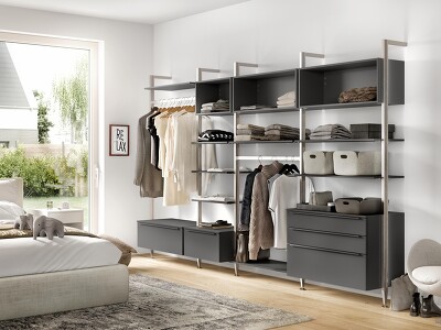 Perfekte Organisation Ihrer Kleidung und Accessoires ist durch die flexible Kombination aus Schränken, Ablageböden, Schubladen, Auszügen und Kleiderstangen individuell planbar. Das supermatte Schiefergrau der TOUCH 334-Schränke bringt einen stilvollen Kontrast in den Raum.